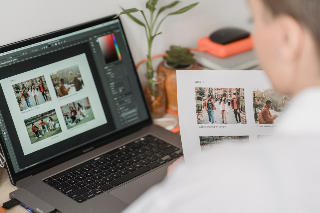 A man analyzes photo edits on a laptop, focusing on design details in a cozy home office environment.